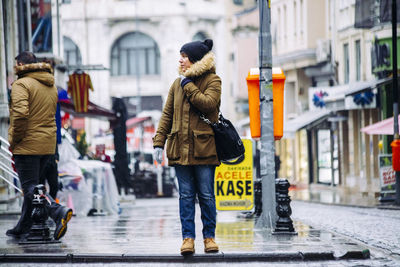 Rear view of woman on wet street during winter