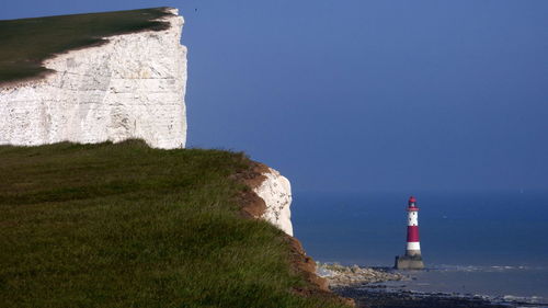 Cliff against beachy head lighthouse in sea