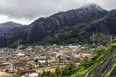 Aerial view of townscape by mountain against sky