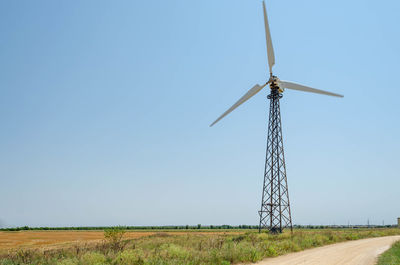 Windmill on field against clear sky