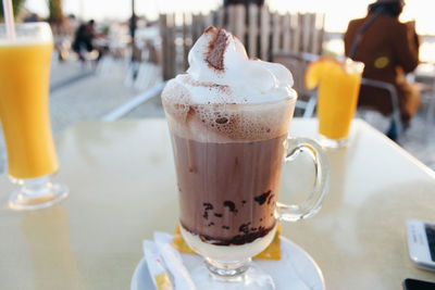 Close-up of coffee with whipped cream served on table at outdoor cafe