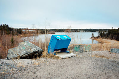 Abandoned built structure on riverbank against sky