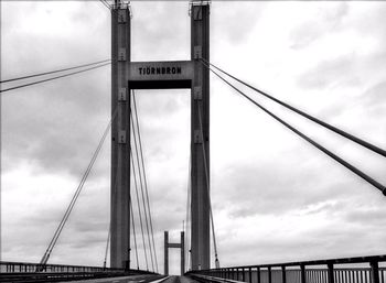 Low angle view of bridge against cloudy sky