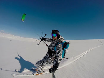 Man skiing on snowcapped mountain against sky