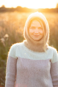 Portrait of smiling woman wearing sweater in field
