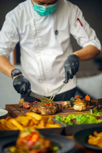 Midsection of man preparing food in kitchen