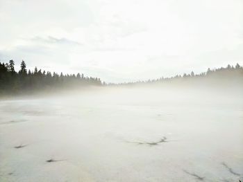 Scenic view of snow covered land against sky