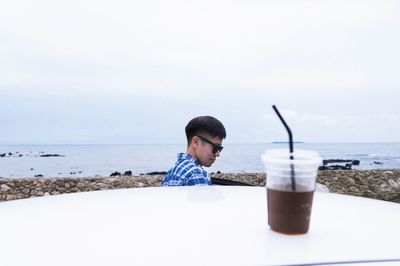 Close-up of drink on car against sky