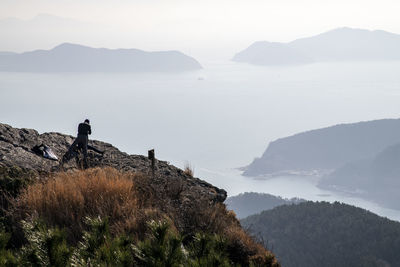 Man standing on mountain against sky