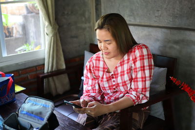 High angle view of woman using mobile phone at home