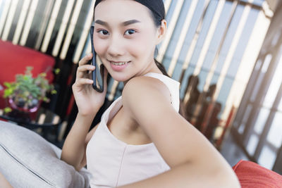 Portrait of smiling young woman using mobile phone