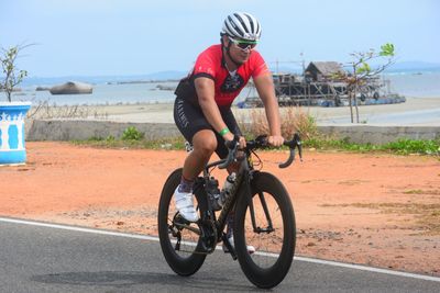 Full length of young woman riding bicycle on beach