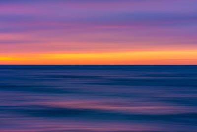 Scenic view of sea against romantic sky at sunset