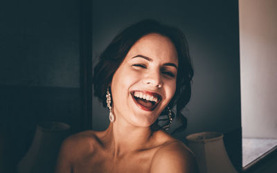 Portrait of young cheerful woman winking at home