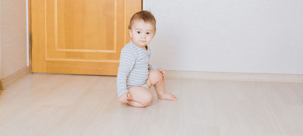 Portrait of cute girl sitting on floor at home