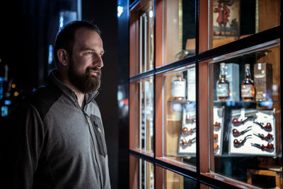 Man looking through window standing outdoors