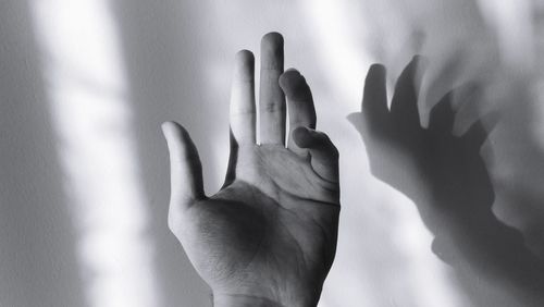 Close-up of hand against wall