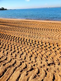 Text on sand at beach against sky