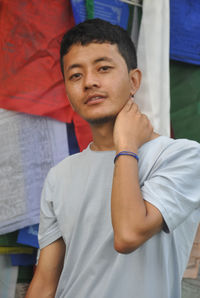 Portrait of young man standing against building