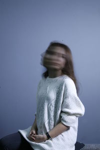 Blurred motion of woman against wall