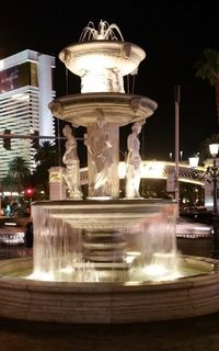 Illuminated fountain in city at night