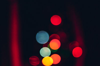 Defocused image of illuminated lights on street at night
