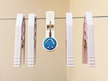 Close-up of clothespins hanging against white wall