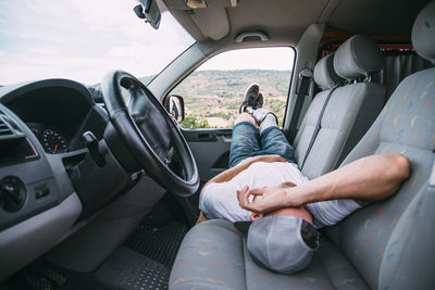 Young man with leg prosthesis resting in camper van