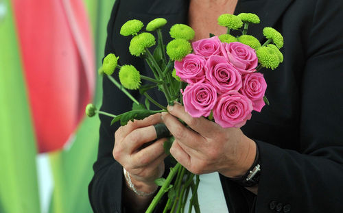 Close-up of hand holding rose bouquet