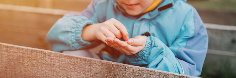 Spring planting seeding farm garden. little kid boy farmer gardener plants sow vegetable seeds soil