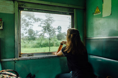 Woman sitting in glass window