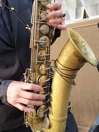 Midsection of man playing guitar at music concert