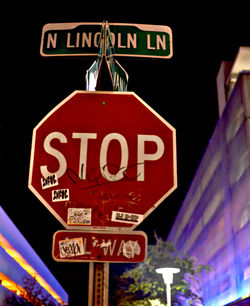 Low angle view of information sign at night