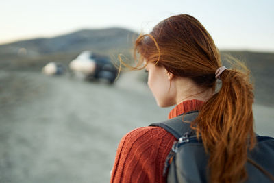 Rear view of woman with arms raised hair