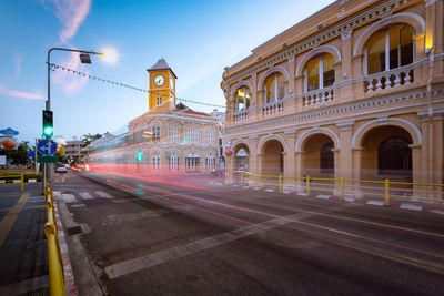 Light trails on city street against sky