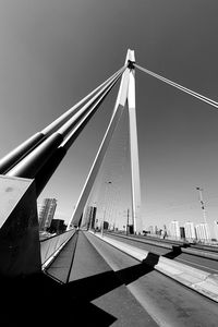 Suspension bridge in city against clear sky