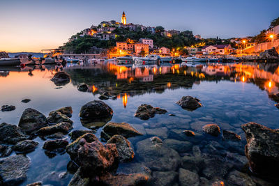 Krk croatia, view over the bay of vrbnik on monday in twilight.  reflection in the harbor basin