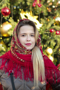 Portrait of woman with red christmas tree