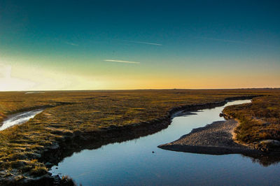 Scenic view of wadden sea against sky during sunset