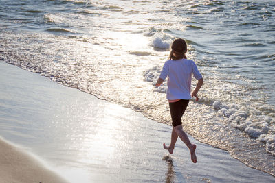 Rear view of woman walking on beach