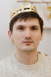 Portrait of a young guy with a crown on his head.