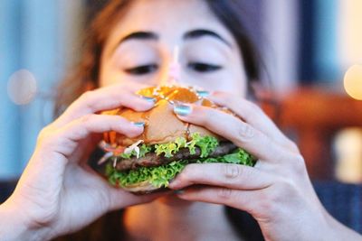 Close-up of woman eating burger