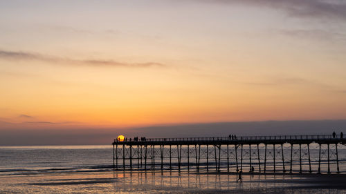 Silhouette pier on sea against sky during sunset