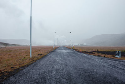 Road leading towards mountain against sky