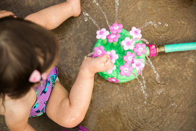 High angle view of child washing feet in fountain