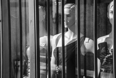 Clothing on mannequin seen through glass window of store