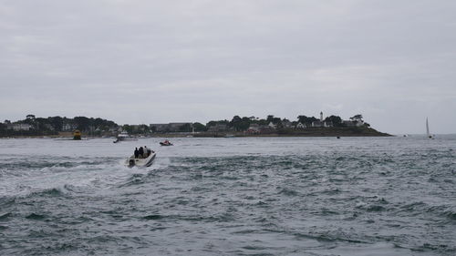 People swimming in sea against sky