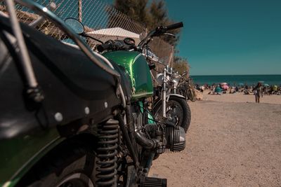 Motorcycle on sand against sky