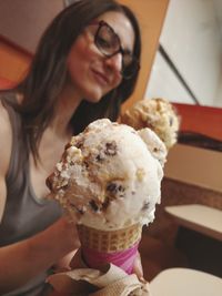 Close-up of woman holding ice cream sundae cone at ice cream parlor