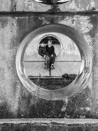 Full length of woman standing by wall of building